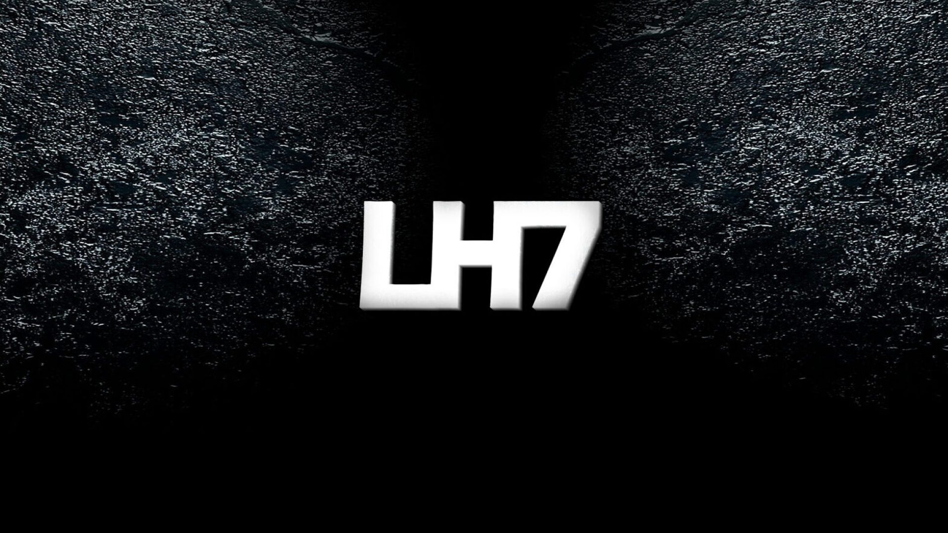 een wit LH7 logo met donker beton achtergrond
